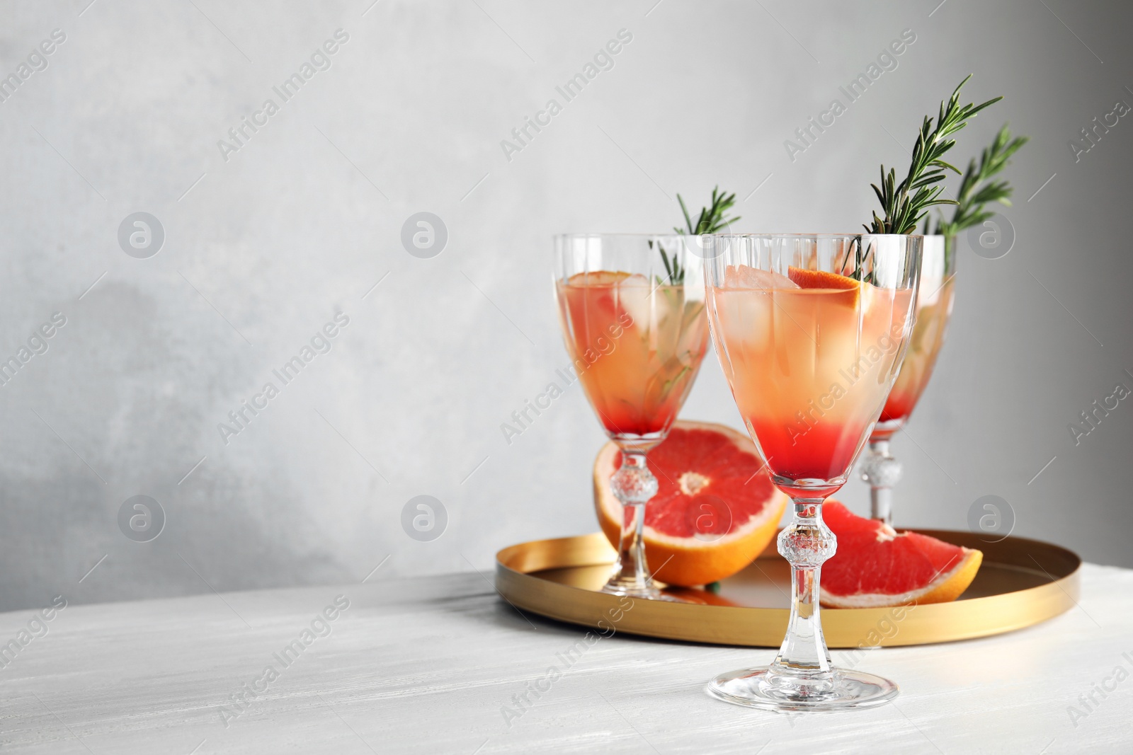 Photo of Glasses of grapefruit cocktails on table. Space for text