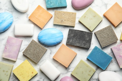 Photo of Many different soap bars on marble table, top view