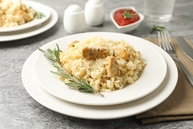 Photo of Delicious chicken risotto served on grey table