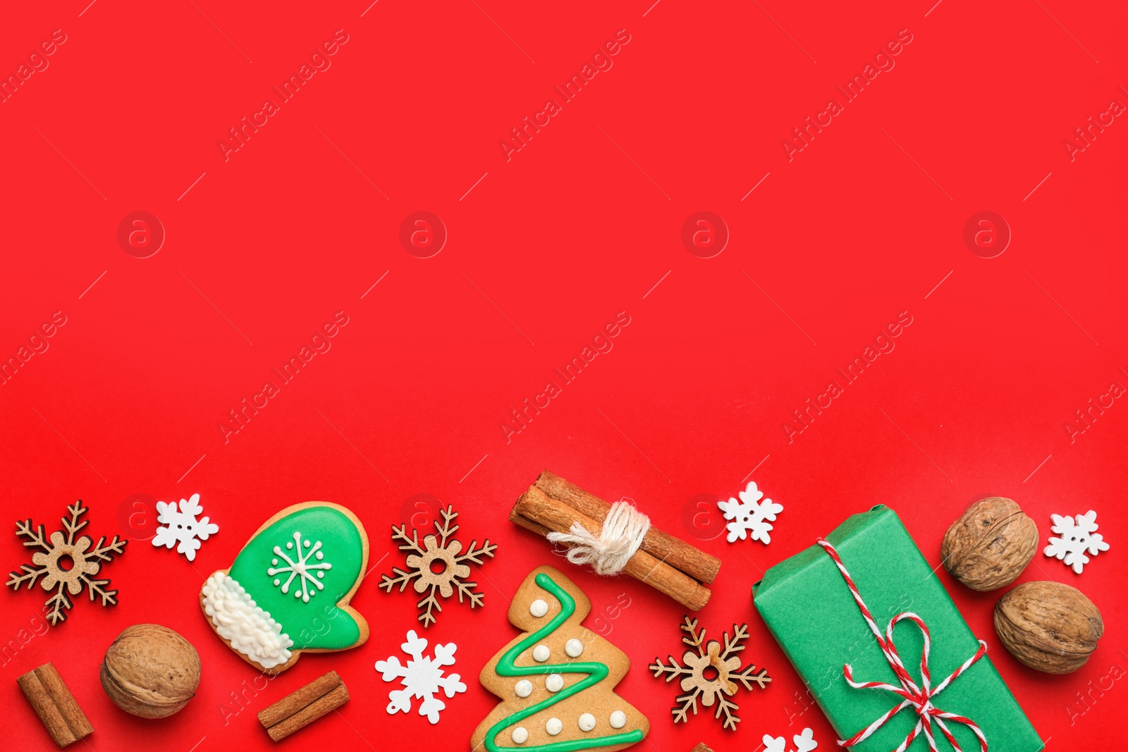 Photo of Flat lay composition with Christmas decorations and treats on red background, space for text. Winter holidays