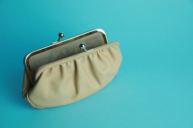 Photo of Open leather purse on light blue background. Space for text