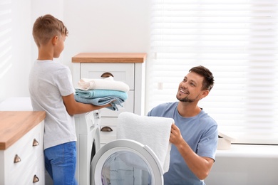 Photo of Dad and son doing laundry at home