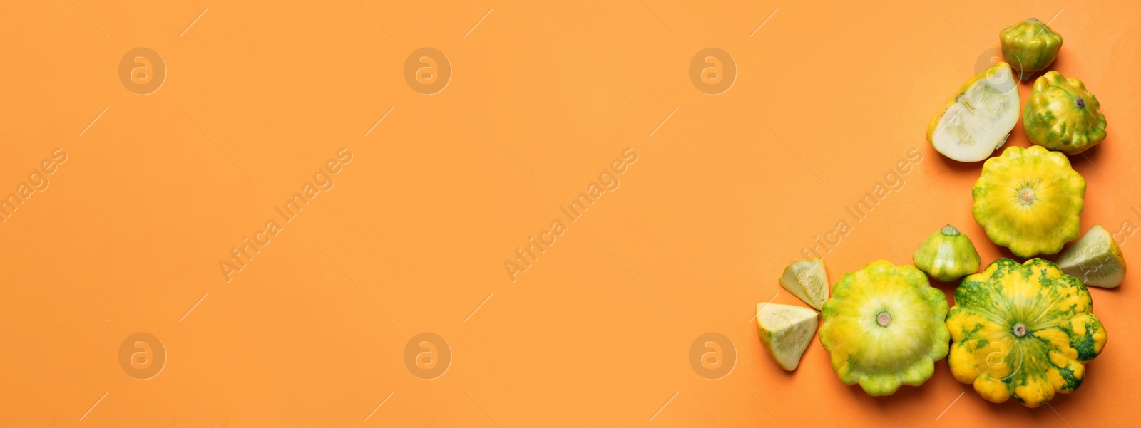 Image of Fresh pattypan squashes on orange background, flat lay with space for text. Banner design