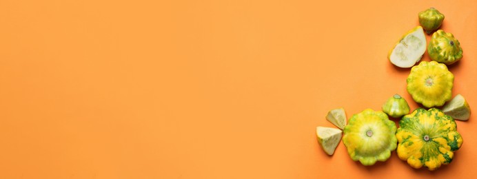 Image of Fresh pattypan squashes on orange background, flat lay with space for text. Banner design