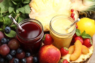 Photo of Delicious colorful juices in glasses and fresh ingredients on table