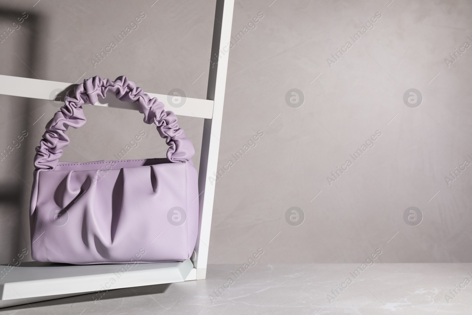 Photo of Stylish women's bag on light grey table. Space for text