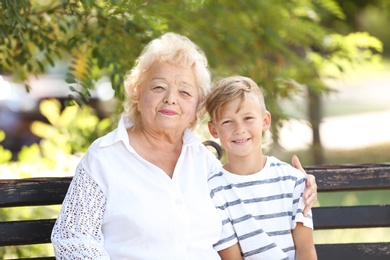 Photo of Elderly woman with grandson on bench in park