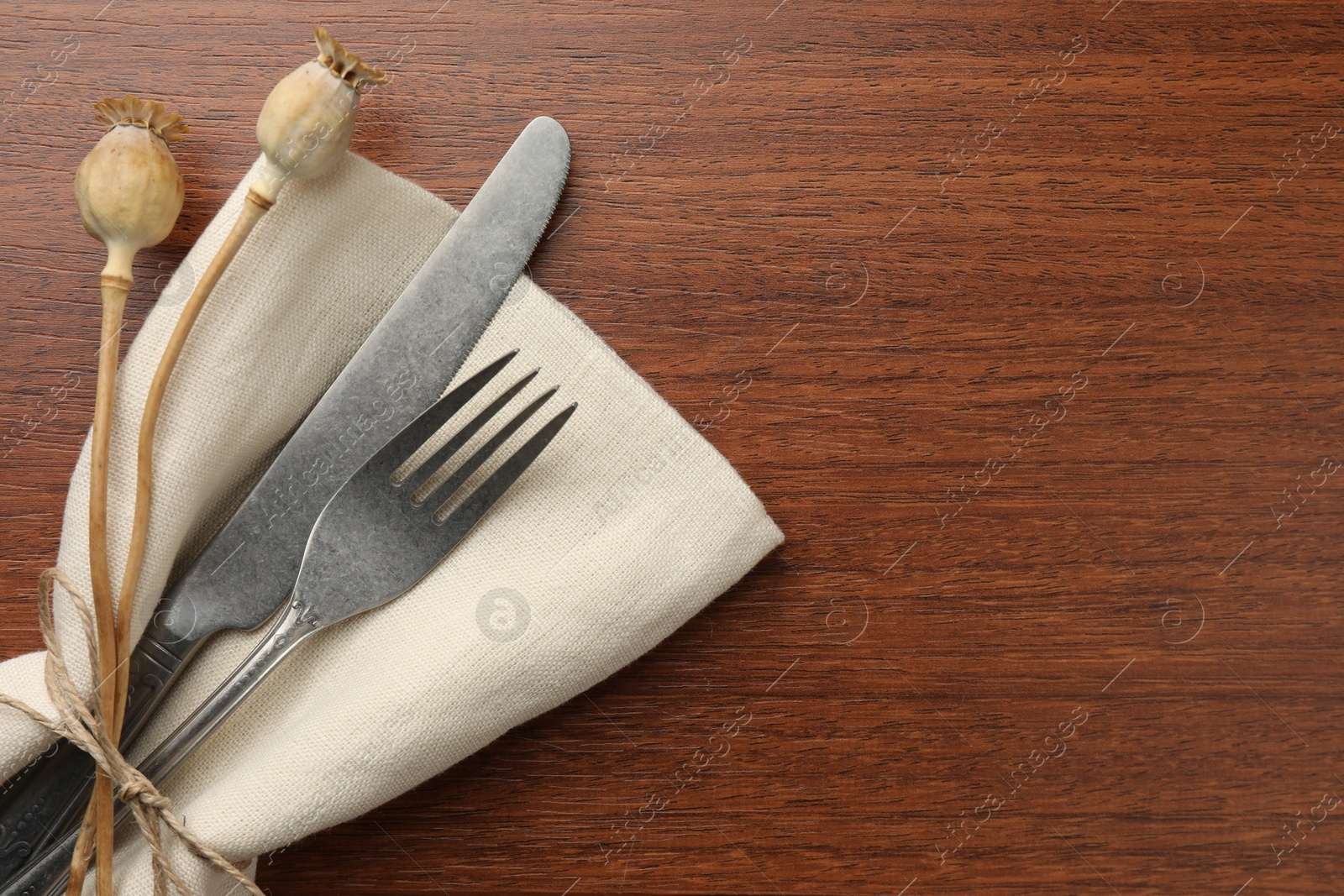 Photo of Stylish setting with cutlery and napkin on wooden table, top view. Space for text