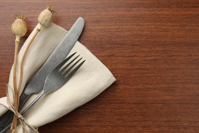 Stylish setting with cutlery and napkin on wooden table, top view. Space for text