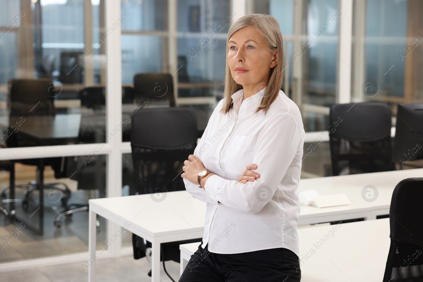 Photo of Confident woman with crossed arms in office. Lawyer, businesswoman, accountant or manager