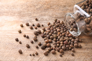 Photo of Scattered peppercorns on wooden table, closeup view