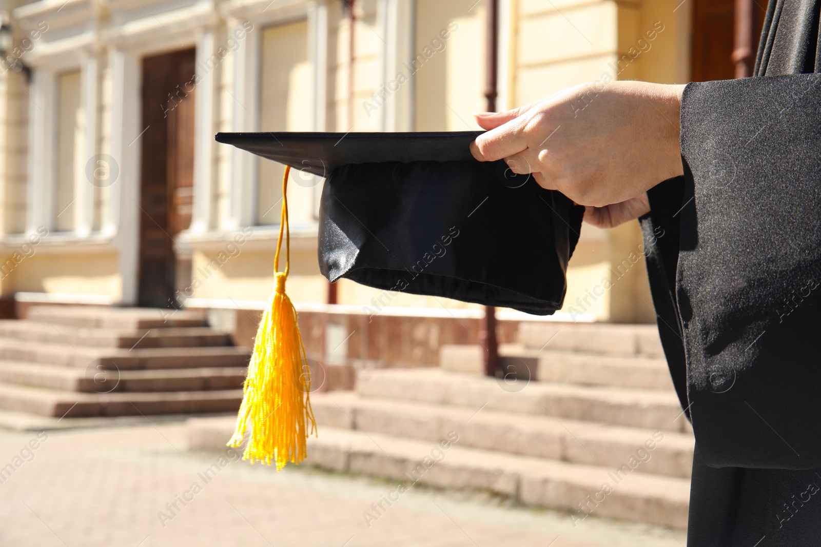 Photo of Student with graduation hat outdoors on sunny day, closeup