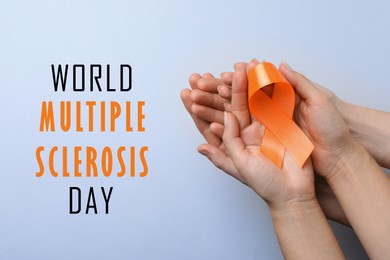 Image of Multiple Sclerosis Awareness Day. People with orange ribbon on light background, top view