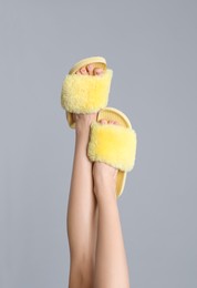 Photo of Woman wearing stylish slippers on grey background, closeup