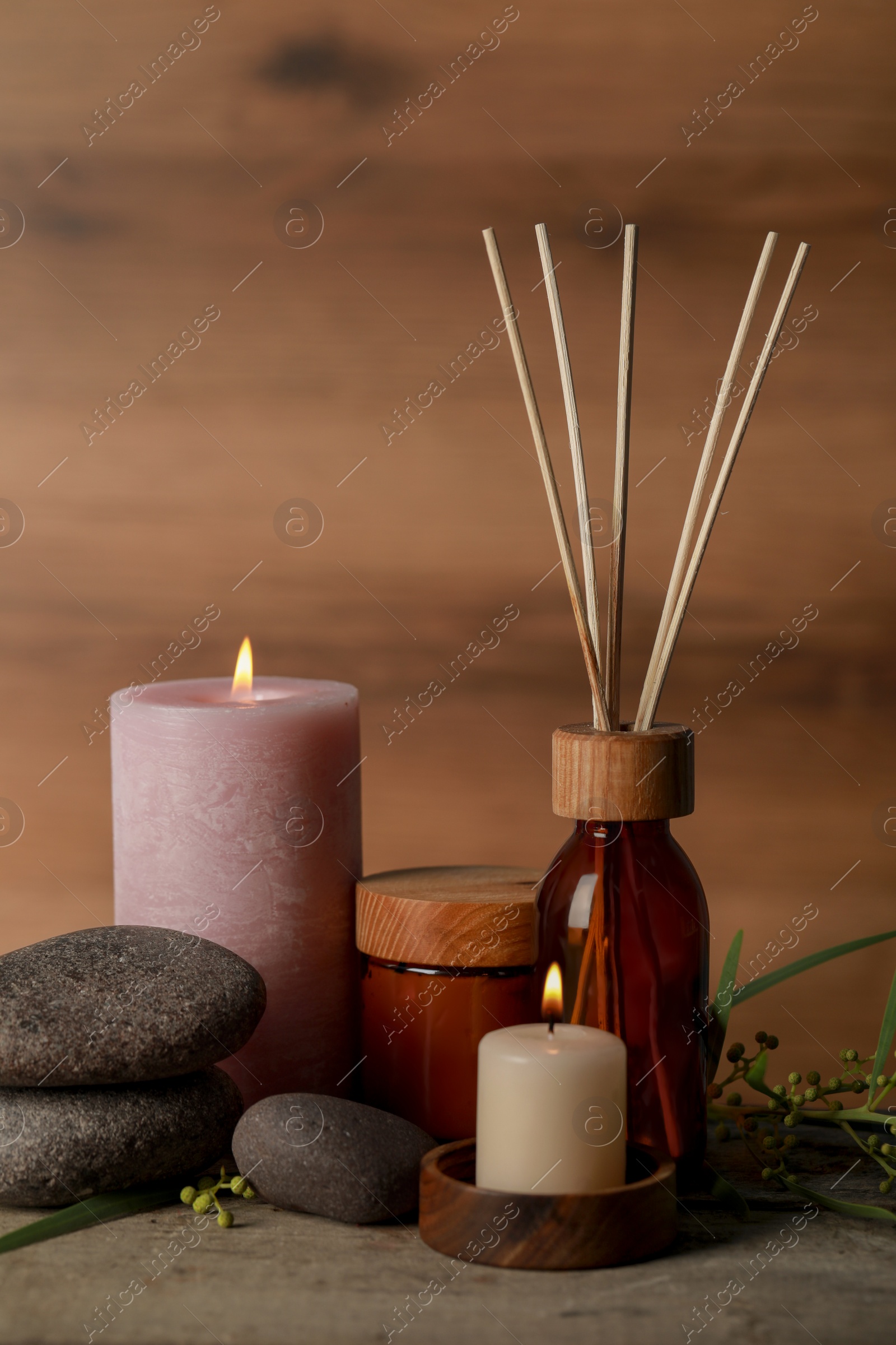 Photo of Beautiful spa composition with different care products and burning candles on wooden table