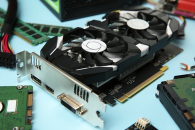 Photo of Graphics card and other computer hardware on light blue background, closeup