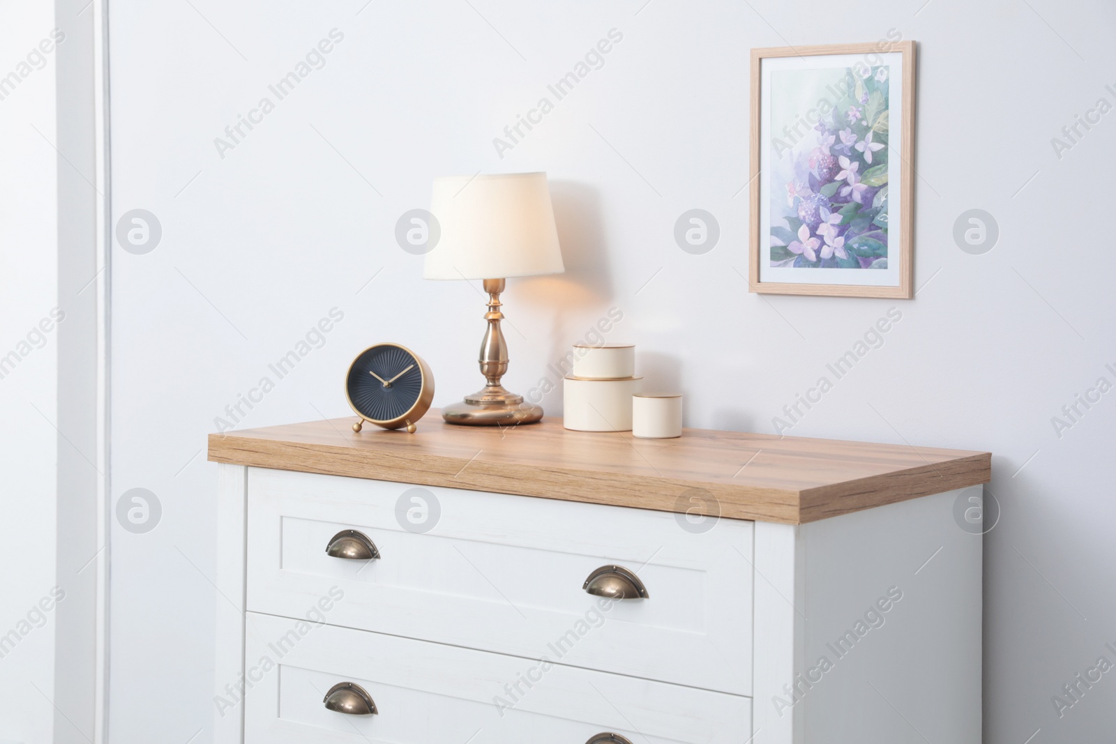 Photo of Stylish chest of drawers near light wall. Interior design