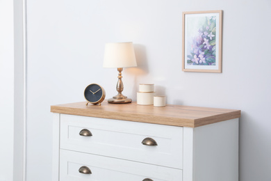 Photo of Stylish chest of drawers near light wall. Interior design