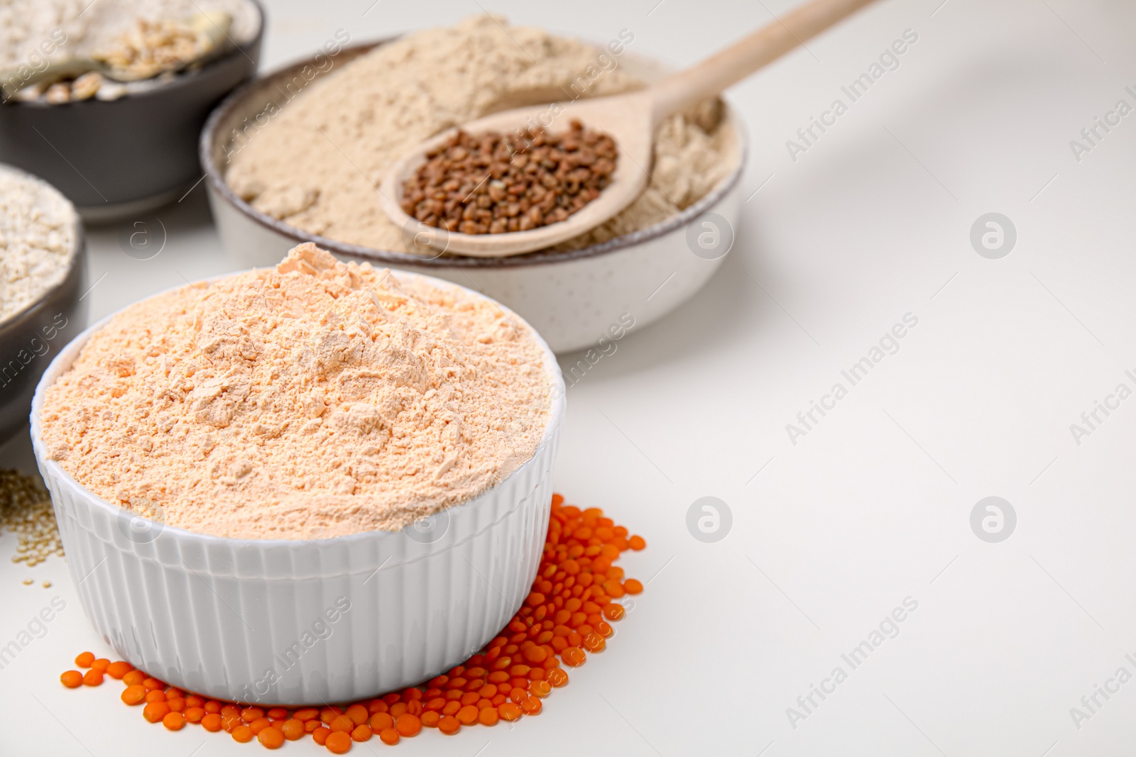 Photo of Different types of flour on white table, closeup