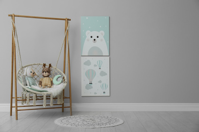 Photo of Stylish child's room interior with adorable paintings and hanging chair. Space for text