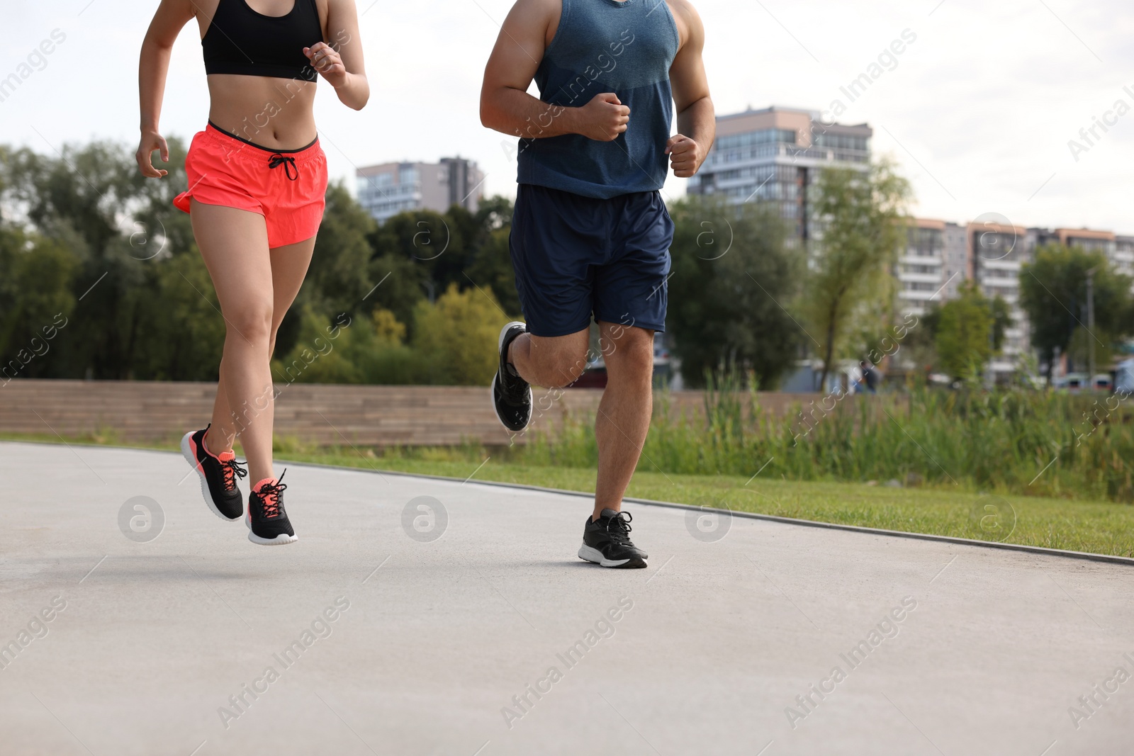 Photo of Healthy lifestyle. Couple running outdoors, closeup. Space for text