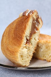Photo of Supreme croissant with chocolate paste and nuts on grey table, closeup. Tasty puff pastry