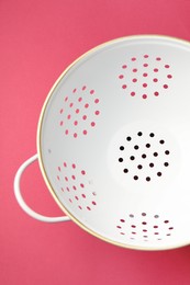 Photo of One clean empty colander on pink table, top view