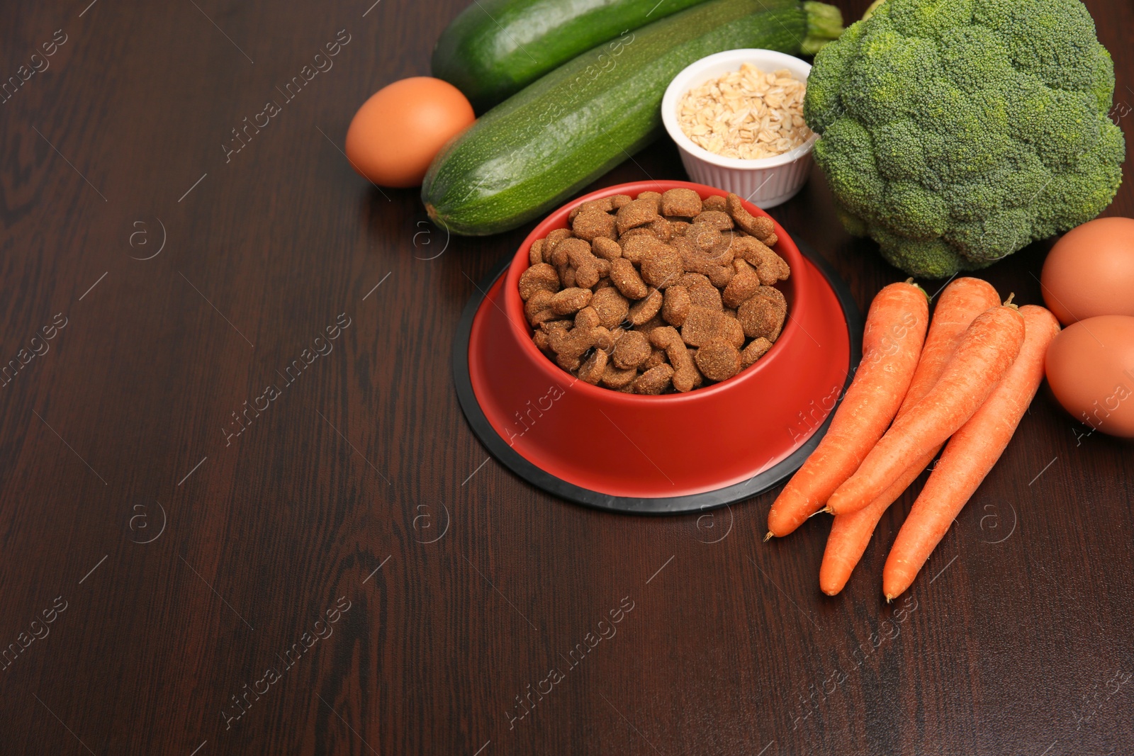 Photo of Dry pet food and products on wooden background. Space for text