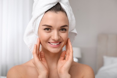 Photo of Beautiful young woman with hair wrapped in towel at home