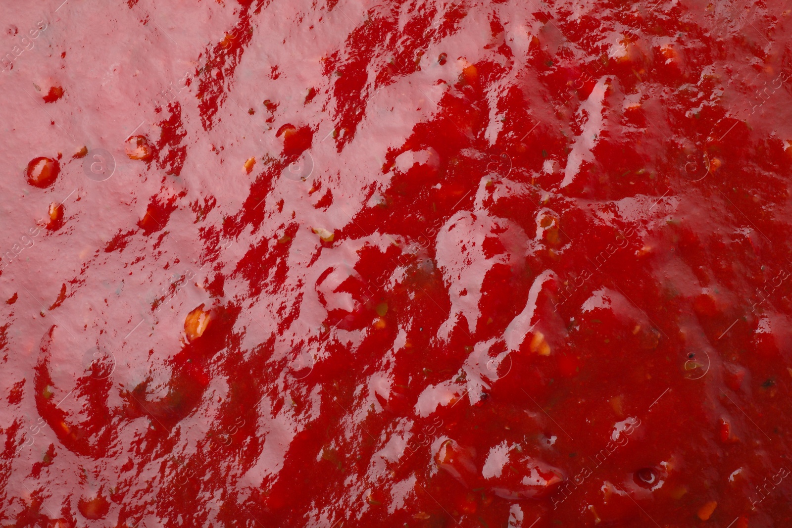 Photo of Tasty red spicy sauce as background, closeup