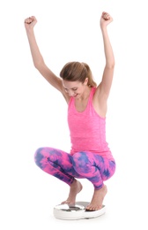 Photo of Happy young woman measuring her weight using scales on white background. Weight loss motivation