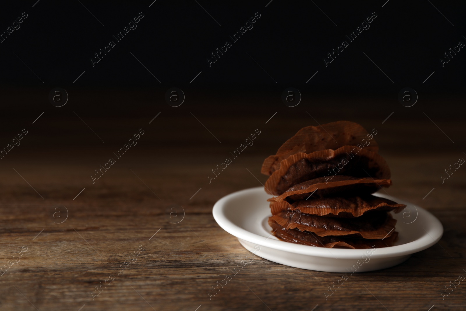 Photo of Saucer with used tea bags on wooden table. Space for text