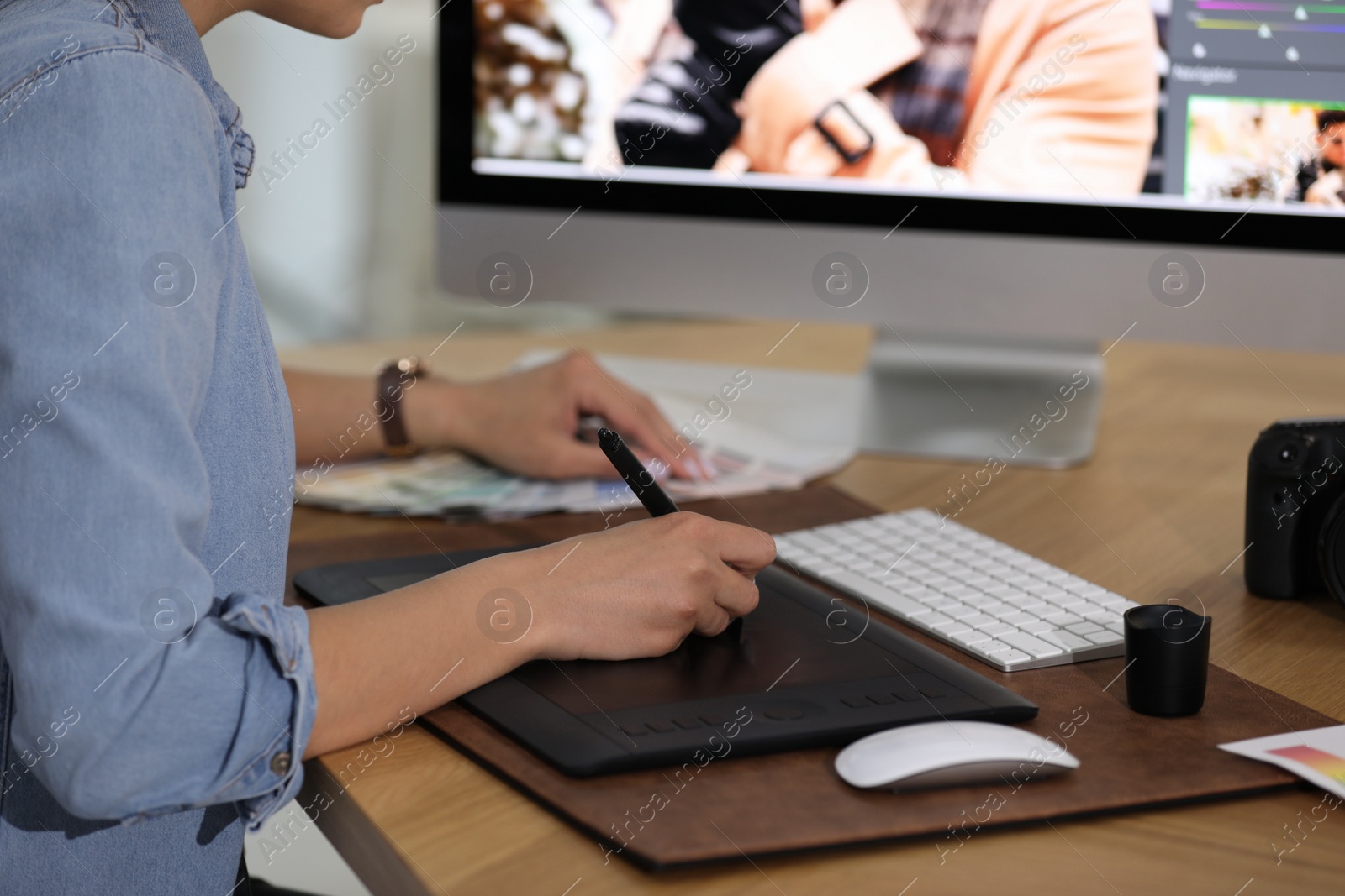 Photo of Professional retoucher working on graphic tablet at table, closeup