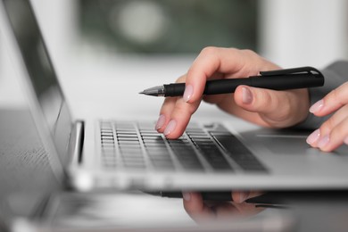 Woman working on laptop at table, closeup. Electronic document management