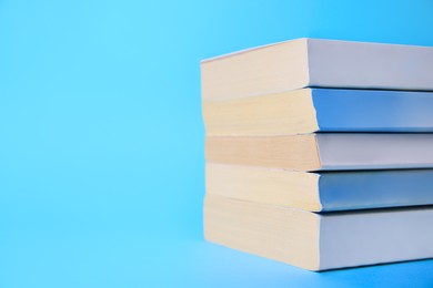 Photo of Collection of books on light blue background, space for text