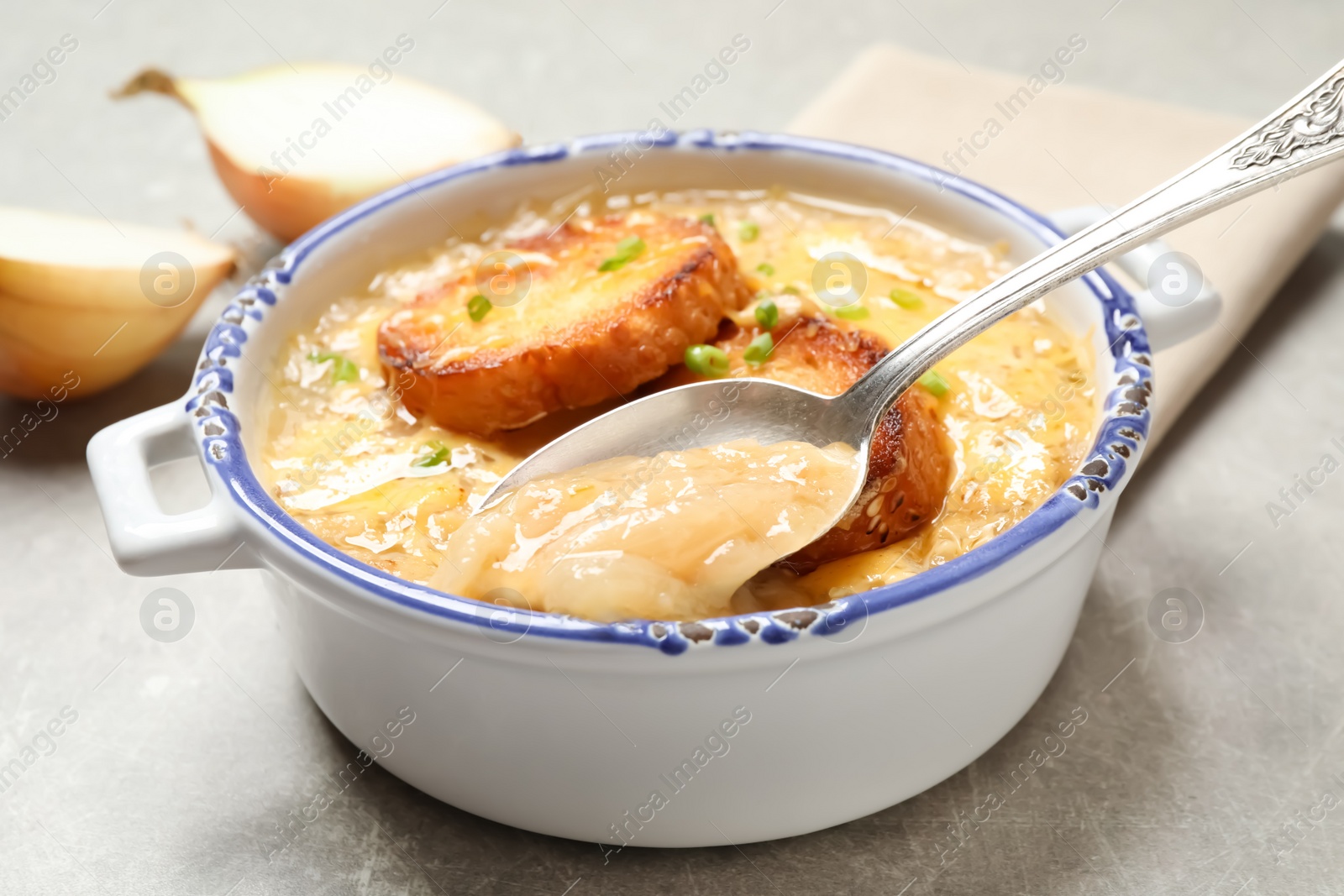 Photo of Tasty homemade french onion soup served on grey table, closeup