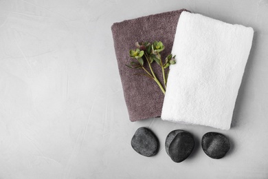 Photo of Flat lay composition with spa stones, towels and space for text on light background