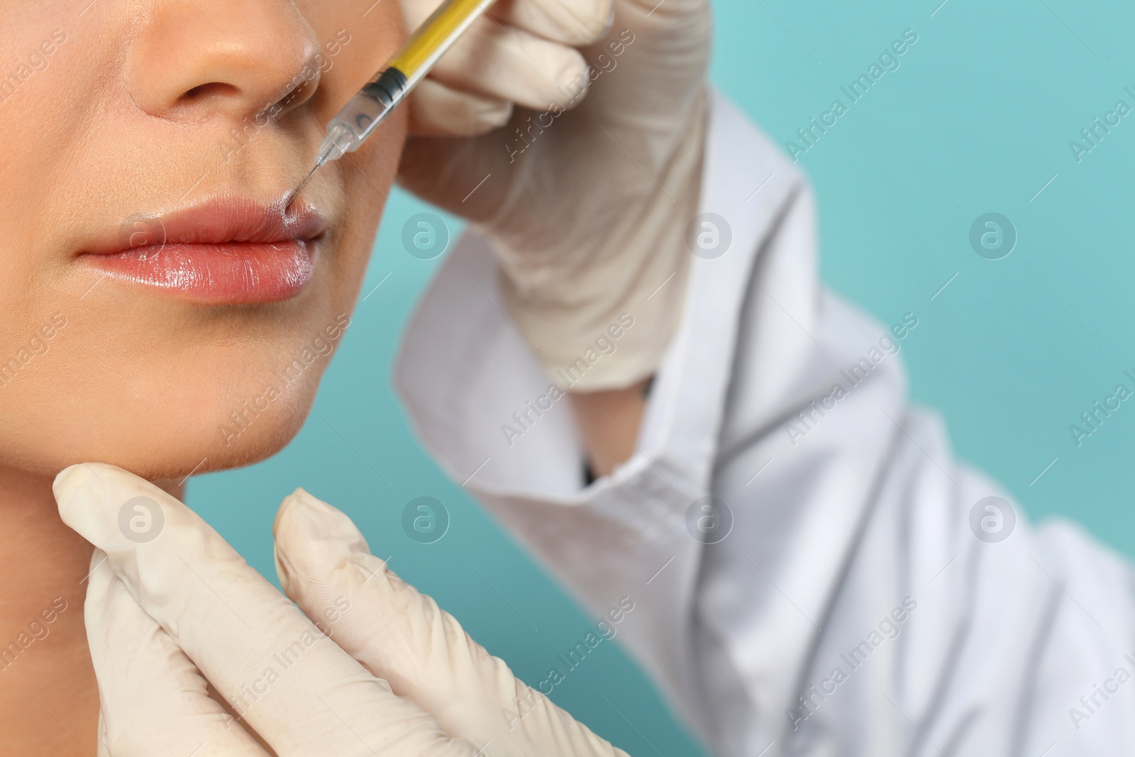 Photo of Young woman getting lips injection on color background, closeup. Cosmetic surgery