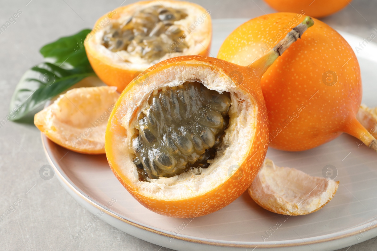 Photo of Delicious ripe granadillas on light table, closeup