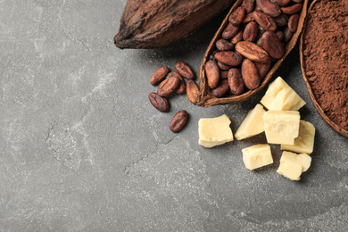 Flat lay composition with organic cocoa butter on grey table. Space for text