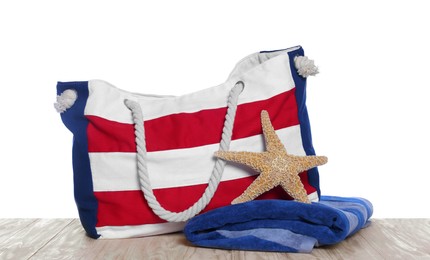 Photo of Stylish striped beach bag, starfish and towel isolated on white