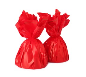 Delicious candies in red wrappers on white background