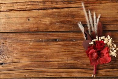 Photo of Beautiful boutonniere on wooden background, top view. Space for text