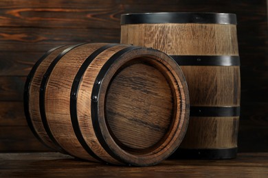 Photo of Two wooden barrels on table near wall, closeup