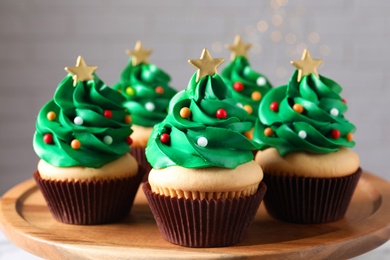 Christmas tree shaped cupcakes on wooden board