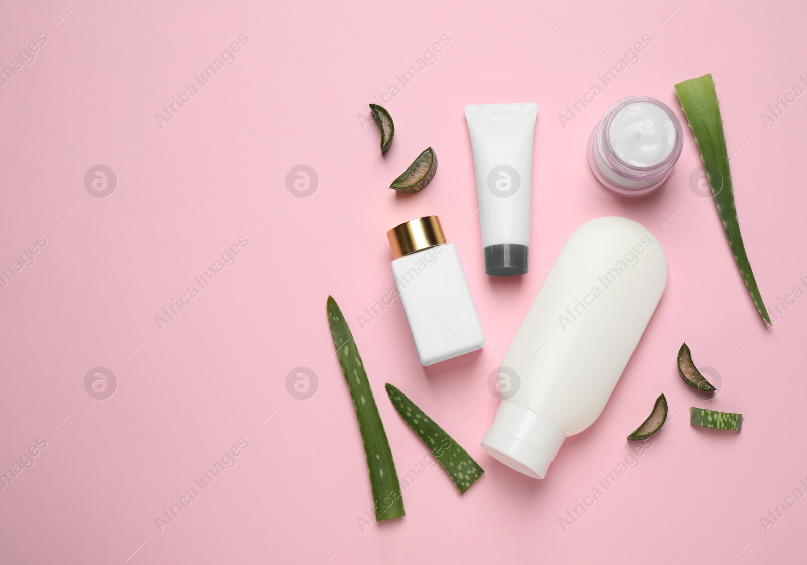 Photo of Flat lay composition with aloe vera and cosmetic products on pink background