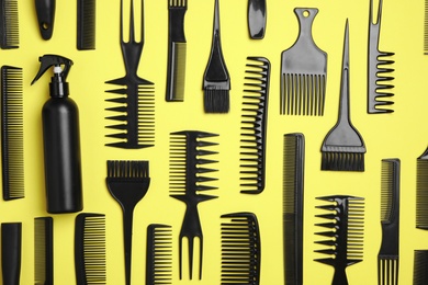 Photo of Flat lay composition with modern hair combs on yellow background