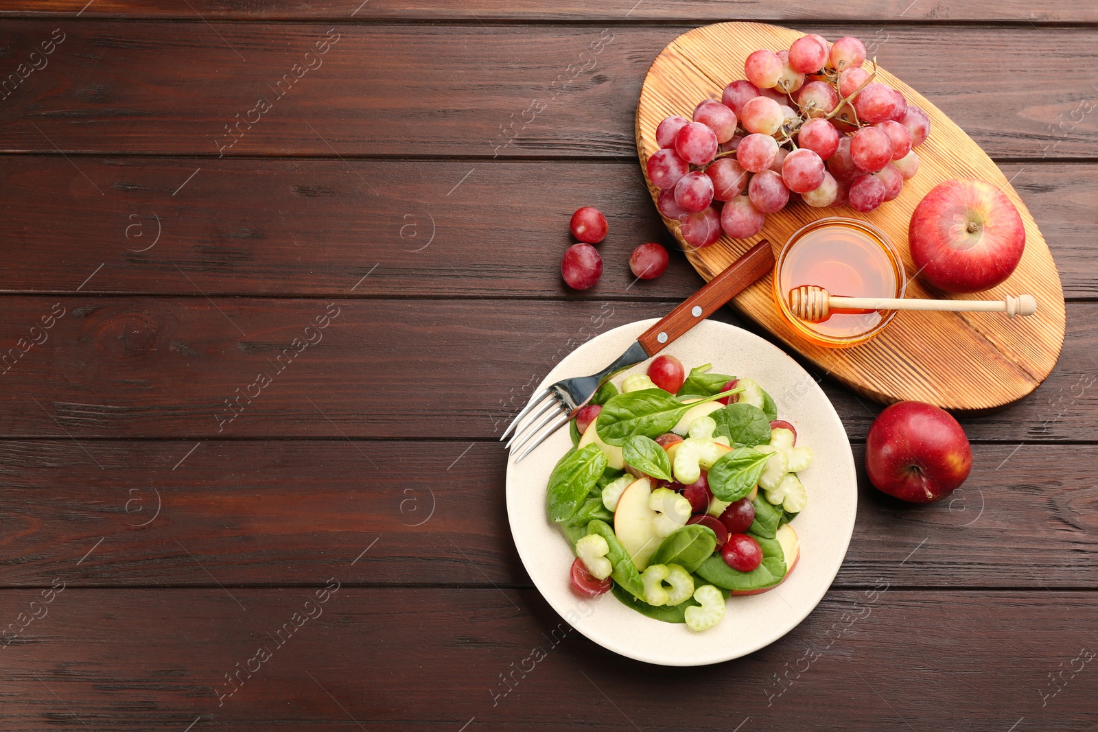 Photo of Delicious fresh celery salad served on wooden table, flat lay. Space for text