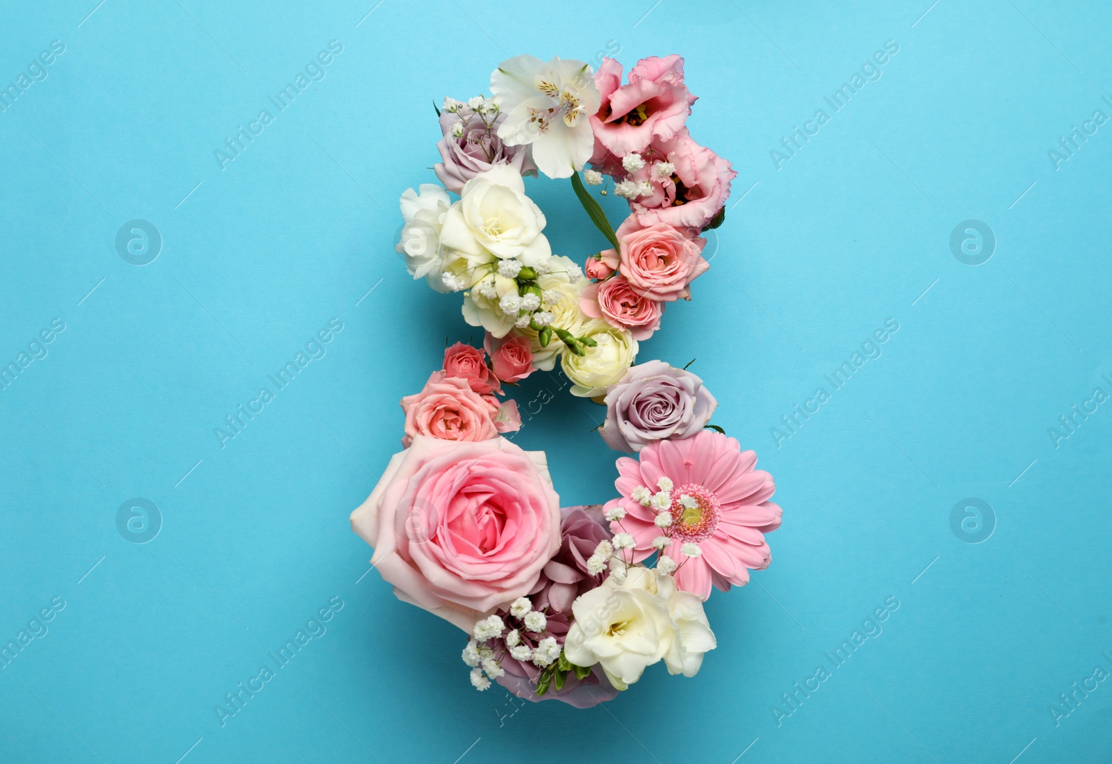 Photo of Number 8 made of beautiful flowers on light blue background, flat lay. International Women's day