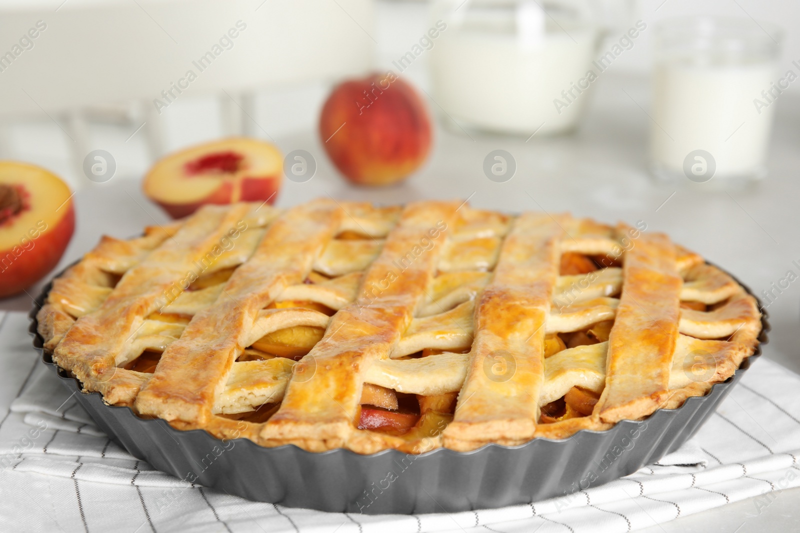 Photo of Delicious fresh peach pie on light kitchen table, closeup